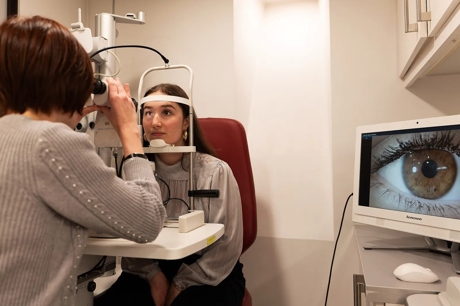 Optométriste examinant la cornée d'une patiente au biomicroscope