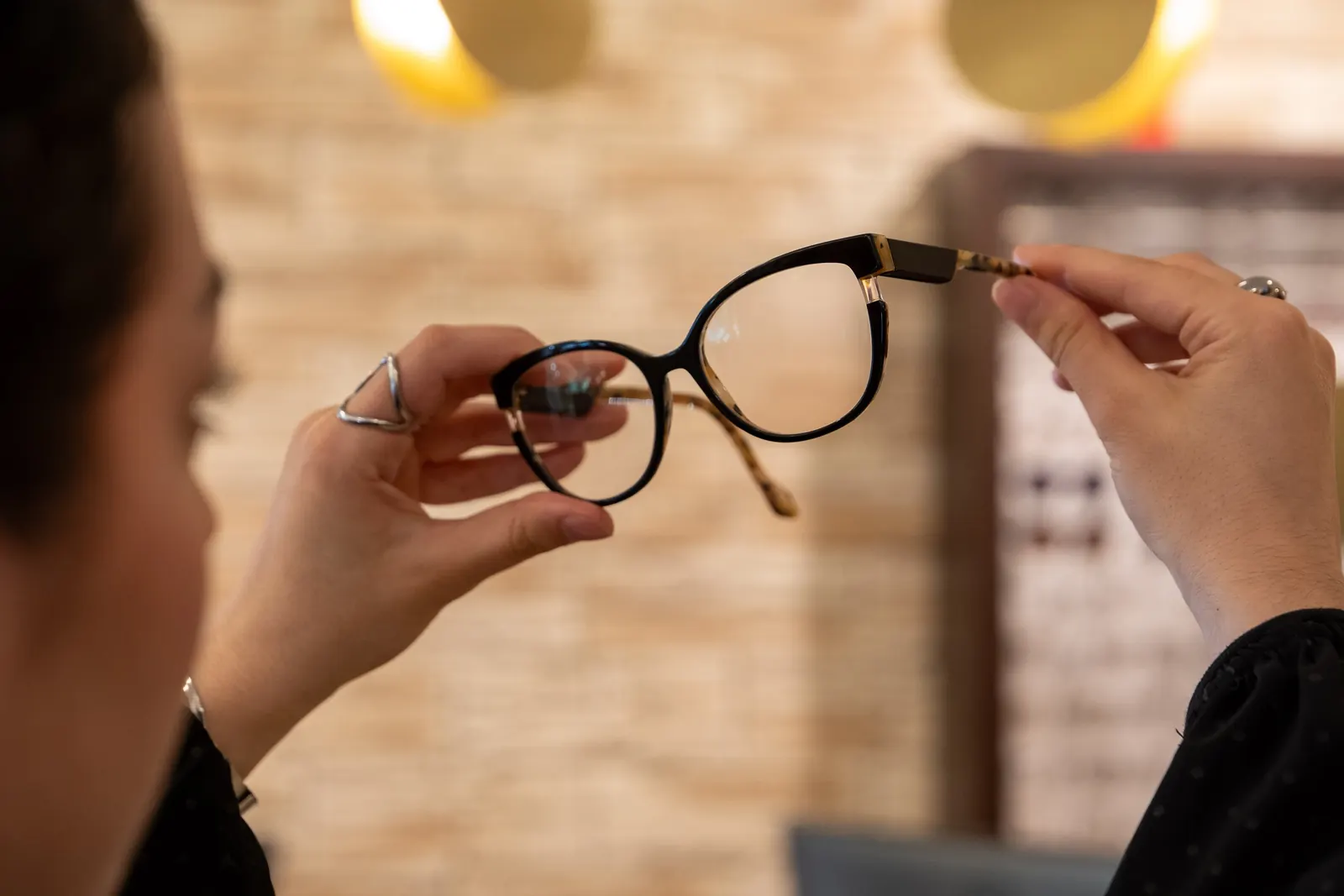 Monture en écaille tenue face à la lumière dans la boutique